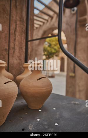 Vaso di terra tenuto vicino al vecchio edificio storico a al Seef, Dubai, Emirati Arabi Uniti Foto Stock