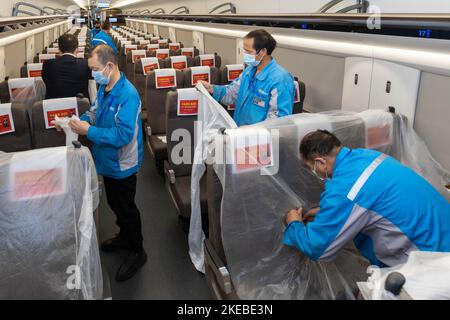 Shanghai. 11th Nov 2022. I membri del personale coprono i posti di un treno passeggeri che viene temporaneamente utilizzato per trasferire le merci alla stazione ferroviaria di Hongqiao, nella Shanghai della Cina orientale, il 11 novembre 2022. Il festival annuale cinese "Double Eleven", che cade il 11 novembre, è stato avviato per la prima volta dalla piattaforma di e-commerce di Alibaba nel 2009 e si è rapidamente trasformato in un importante evento di shopping. Credit: Wang Xiang/Xinhua/Alamy Live News Foto Stock