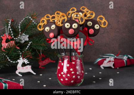 Simpatica idea per le delizie natalizie - dolci papavero renne Santas a base di biscotti al cioccolato e cracker su sfondo marrone Foto Stock
