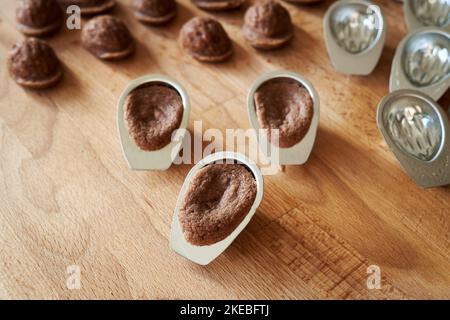 Biscotti di Natale fatti in casa appena sfornati sotto forma di noci in stampi di latta Foto Stock