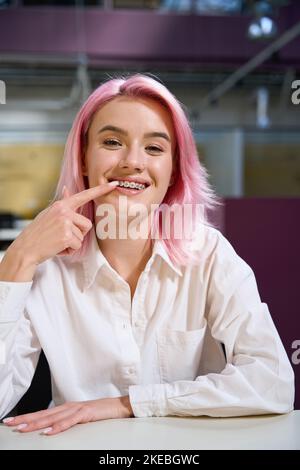 Donna felice che mostra le sue bretelle appena montate Foto Stock