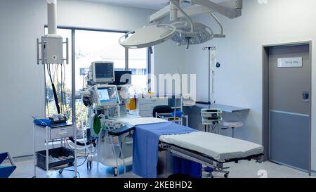 Apparecchiature mediche, tecnologia e illuminazione sul tavolo operatorio in una sala operatoria vuota dell'ospedale Foto Stock