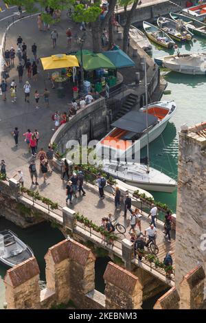 Ponte di Sirmione, veduta di chi cammina sullo stretto ponte che permette di raggiungere la città di Sirmione dal suo lato meridionale, il Lago di Garda Foto Stock