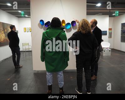 La vista di un uomo che spiega le opere d'arte ai visitatori durante la Discovery Art Fair di Francoforte Foto Stock