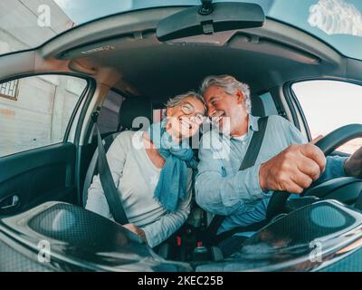 Coppia di due anziani felici divertirsi e godersi le vacanze viaggio insieme alla guida e alla scoperta di nuovi posti con una macchina. Foto Stock