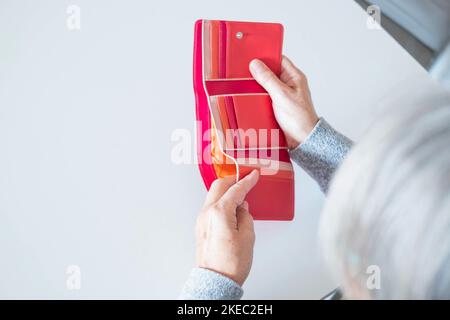 primo piano di mani di donna matura guardando e revisionando quanti soldi ha nel suo portafoglio - vuoto portafoglio e che hanno bisogno di soldi concetto e stile di vita Foto Stock