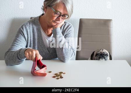 coppia di donna matura e piccolo pug contando i soldi e. quanti guadagnano questo mese - problema economico Foto Stock