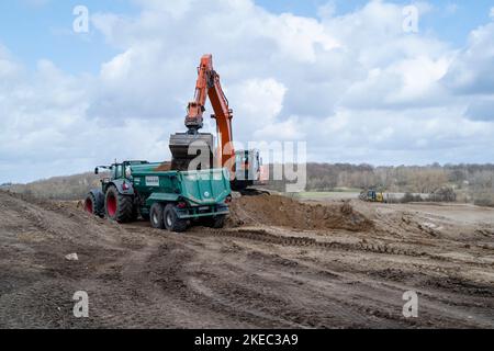 Cantiere con escavatore e trattore in estate Foto Stock