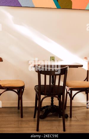 Tavolo in legno nel caffè e sedie. Stile loft Foto Stock
