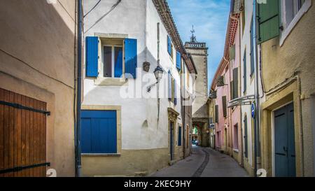 Village strada in Nissan lez Enserune. Il Tour de l'Horloge è stato costruito nel 1731 e servito come uno degli ingressi della città vecchia. Foto Stock