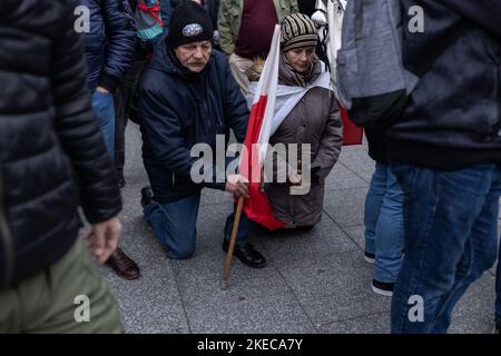 Varsavia, Polonia. 11th Nov 2022. La gente prega in ginocchio durante la marcia dell'Indipendenza per celebrare il 104th° anniversario dell'indipendenza polacca, a Varsavia, Polonia 11 novembre 2022 Credit: Kamil Jasinski/Alamy Live News Foto Stock