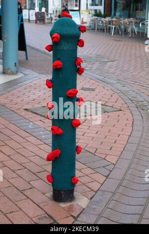 Chesham, Buckinghamshire. REGNO UNITO. 11 Novembre 2022. Un post avvolto con una copertina a maglia e papaveri a Chesham per il giorno della commemorazione Foto Stock