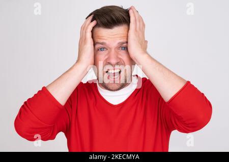 L'uomo preoccupato caucasico tiene la testa nelle mani sembra preoccupato. Foto Stock