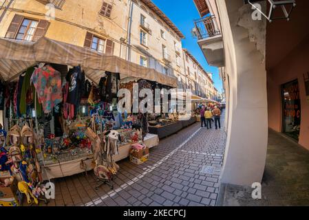 Carmagnola, Torino, Italia - 05 novembre 2022: Sabato bancarelle in via Ferruccio Valobra, via centrale con portici nel centro storico Foto Stock