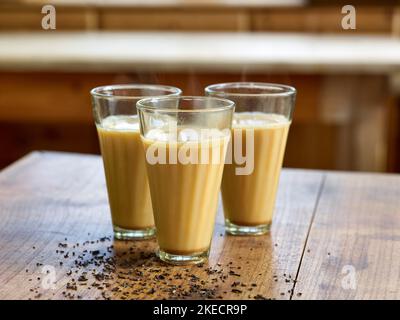 Cucina ayurvedica, tre bicchieri di tè Golden Chai con latte o latte d'avena Foto Stock