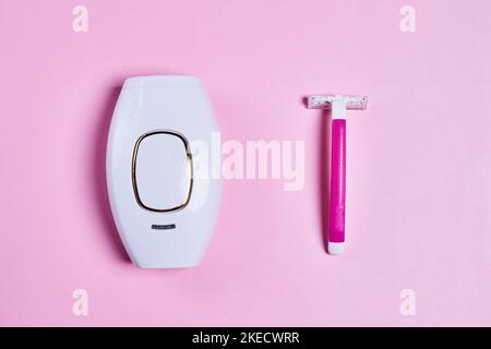 uno spazzolino elettrico accanto a uno spazzolino da rasoio su sfondo rosa con spazio copia nell'angolo superiore destro Foto Stock