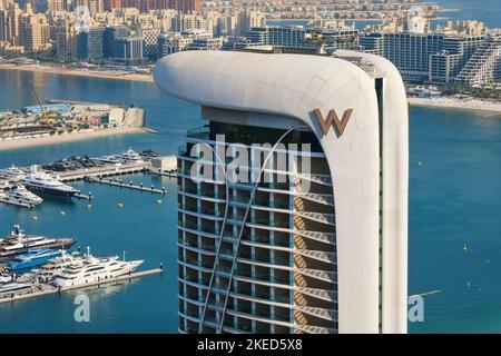 Dubai, Emirati Arabi Uniti, Novembre 2022: Facciata futuristica del grattacielo W Hotel con logo W nel porto di Jumeirah, lussuoso hotel a 5 stelle con skyline urbano sullo sfondo Foto Stock