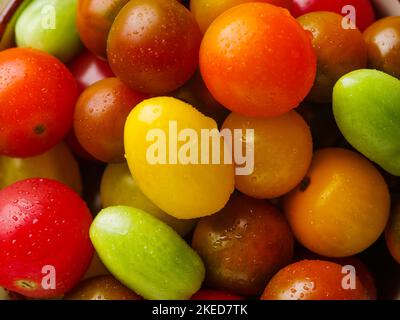 Molti pomodori colorati e luminosi. Cibo sfondo. Composizione appetitosa. Vitamine, antiossidanti, alimenti biologici. Libro di ricette, blog di cibo. Non ci sono Foto Stock