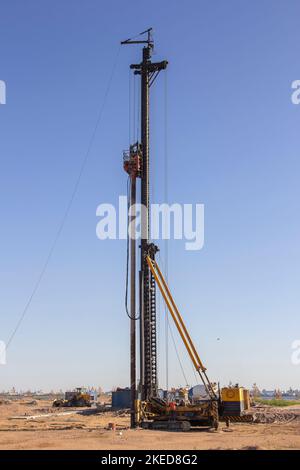 Carro di perforazione idraulico per l'installazione di pali perforati in cantiere. Foto Stock