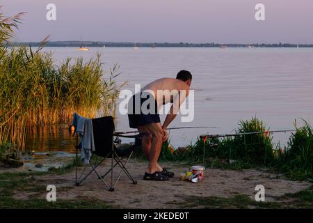 Un pescatore paziente sta aspettando con ansia un'esca al lago Balaton - Revfusop, Ungheria Foto Stock