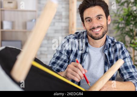 falegname uomo che lavora in officina di riparazione mobili Foto Stock