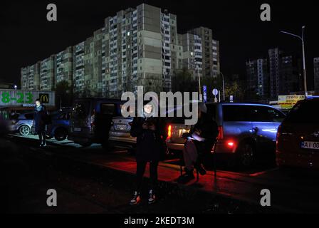 Kiev, Ucraina. 11th Nov 2022. Una donna usa il suo telefono per illuminare una fermata oscura dei trasporti pubblici a Kiev. L'esercito russo ha effettuato massicci attacchi di razzo e droni kamikaze sulle infrastrutture energetiche ucraine. Secondo le stime degli esperti, il 40% delle infrastrutture energetiche è ora distrutto o danneggiato. Dopo gravi danni alla rete elettrica in molte città dell'Ucraina, la National Power Company Ukrenergo ha introdotto blackout di emergenza e orari di energia elettrica. Credit: SOPA Images Limited/Alamy Live News Foto Stock