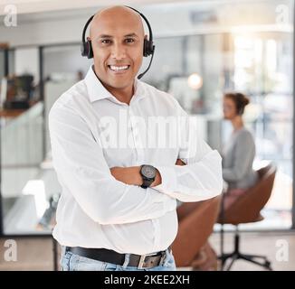 Uomo d'affari, call center e braccia incrociate con sorriso per il telemarketing, il servizio clienti o il supporto in ufficio. Ritratto di uomo felice e fiducioso Foto Stock