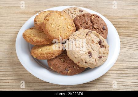 Vari biscotti in piastra su sfondo di legno primo piano Foto Stock