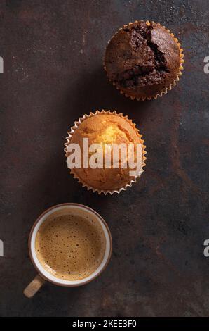 Muffin e tazza di caffè su uno sfondo di metallo grunge, vista dall'alto Foto Stock