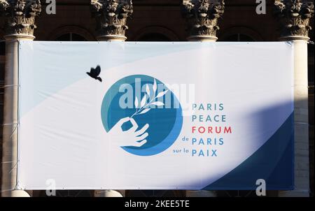 Parigi, Francia. 11th Nov 2022. Un piccione vola accanto all'enorme poster del Forum di pace di Parigi fuori dal Palais Brongniart, dove si tiene il quinto Forum di pace di Parigi, a Parigi, in Francia, il 11 novembre 2022. Il quinto Forum di pace di Parigi è stato inaugurato venerdì, con il tema "cavalcare la multicrisis”. Credit: Gao Jing/Xinhua/Alamy Live News Foto Stock