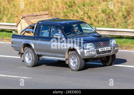 2004 Blue MITSUBISHI L200 Double Cab 2,5TD 4WD DCB 4Life 2477cc Diesel pick-up manuale a 5 velocità con canile in legno; viaggiando sull'autostrada M6 UK Foto Stock