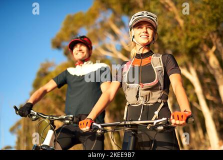 La mountain bike è solo un po' di divertimento, una giovane coppia in mountain bike. Foto Stock