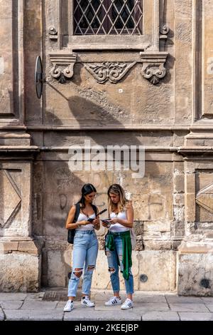 Due giovani Donne alla ricerca di Una mappa turistica, Palermo, Sicilia, Italia. Foto Stock