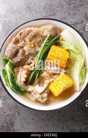 Il Bulalo di manzo è una popolare zuppa di manzo filippina con verdure come il cavolo di Napa, la cipolla verde, il bok choy e il mais closeup nel recipiente sul tavolo. Ver Foto Stock