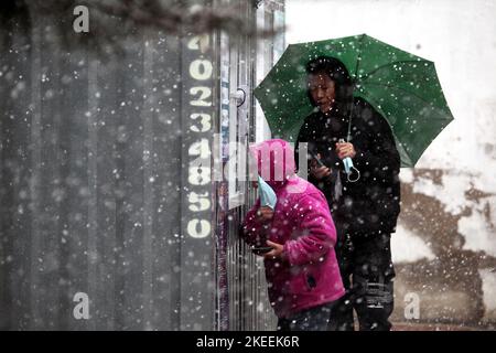 SHENYANG, CINA - NOVEMBER12, 2022 - la gente tiene gli ombrelli sotto la neve per il test degli acidi nucleici a Shenyang, provincia di Liaoning, Cina, 12 novembre 2022. Foto Stock