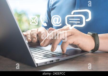 Contattaci. Businessman che digita sul portatile con posta, telefono, e-mail icona virtuale. Concetto di supporto cutomer. Comunicazione aziendale. Comunicazione e cont Foto Stock