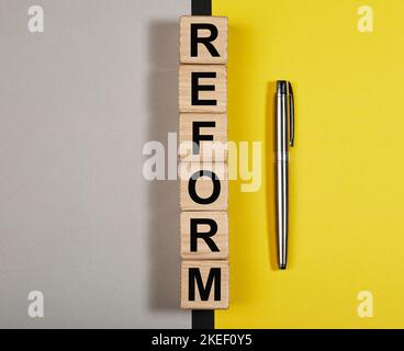 Parola di riforma su cubi di legno. Concetto di pro e contro degli emendamenti. Foto Stock