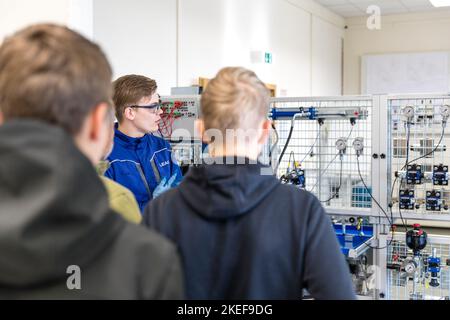 12 novembre 2022, Brandeburgo, Schwarze Pumpe: Fabien Wüstner è un tecnico meccatronico nel suo terzo anno di formazione. Qui mostra i giovani interessati a formare un circuito di prova nell'armadio idraulico del centro di formazione LEAG. Lausitz Energie Bergbau AG e Lausitz Energie Kraftwerke AG (LEAG) stanno organizzando una giornata all'aperto nel parco industriale di Schwarze Pumpe, dove gli interessati possono guardare le spalle di apprendisti e formatori. LEAG sta cercando di occupare 100 posti vacanti in apprendistato tecnico-industriale e commerciale, nonché in due programmi di studio duale. Foto: Frank H Foto Stock