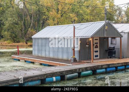 Vecchia casa di barche in alluminio o acciaio sull'isola di Latsch nelle acque posteriori del fiume Mississippi a Winona, Minnesota USA. Foto Stock