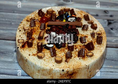 Torta festosa al cioccolato al caramello ricoperta di caramello e panna  montata, farcita con crema alla vaniglia e noci, e decorata con diversi  tipi di choc Foto stock - Alamy