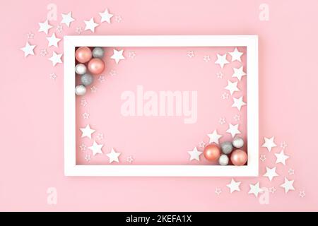Natale e Capodanno sfondo festivo su rosa pastello con fiocchi di neve e decorazioni rotonde albero di bauble con cornice bianca. Design del bordo minimale per Foto Stock