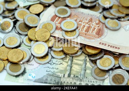 Pile di banconote e monete egiziane di 1 EGP LE una libbra egiziana e mezzo una libbra 50 cinquanta piasters, pile di sfondo di valuta egiziana, eco Foto Stock