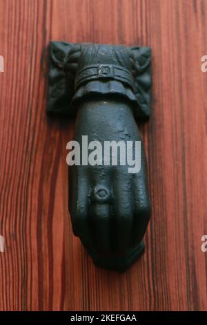 Doorknoccker di ferro a forma di mano su Old Wooden Door in Alcudia Spagna Foto Stock