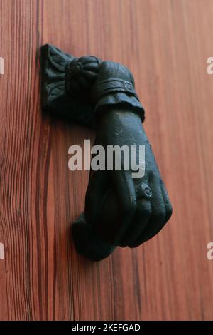 Doorknoccker di ferro a forma di mano su Old Wooden Door in Alcudia Spagna Foto Stock