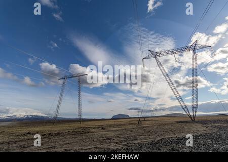 Le linee elettriche in Islanda contro un cielo nuvoloso blu Foto Stock