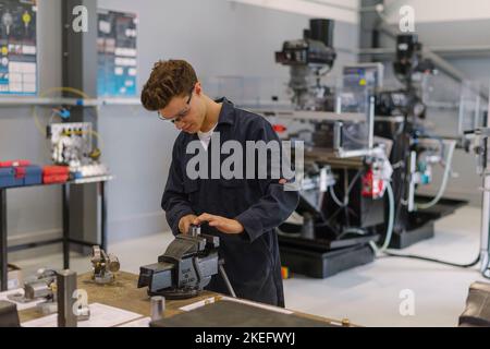 Uno studente di ingegneria che utilizza strumenti in un centro di ingegneria, università, università. Foto Stock