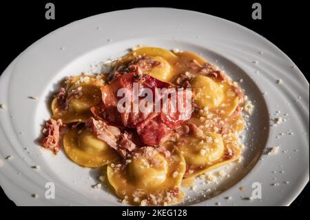 Agnolotti fatti a mano con speck, tipo di ravioli, tipica pasta all'uovo italiana piemontese, Italia settentrionale - fuoco selettivo con profondità bassa di Foto Stock