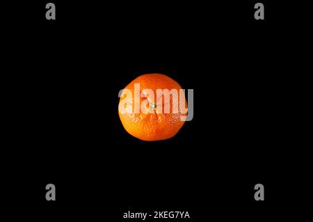 Vista dall'alto di un singolo tangerino arancione isolato su sfondo nero Foto Stock