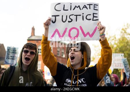 CARDIFF, GALLES - 12 NOVEMBRE: Un uomo ha in mano un segno che dice “giustizia del clima ora” durante una protesta per la giustizia del clima il 12 novembre 2022 Foto Stock