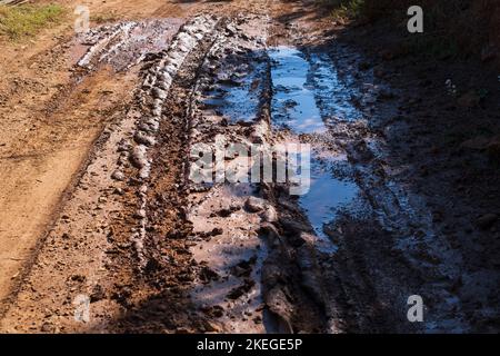 Fango e pozzanghere sulla strada sterrata Foto Stock